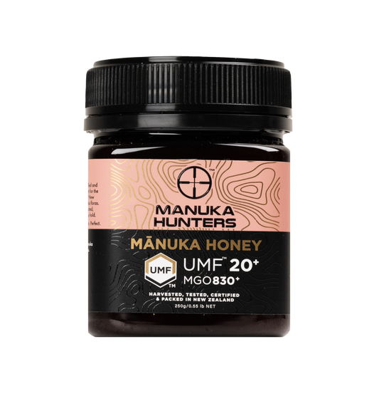 A jar of Mānuka Honey 20+ UMF™ (830MGO) 250g with a black label and pink and gold text, indicating it is a premium, high-UMF certified honey from New Zealand's Manuka Hunters.