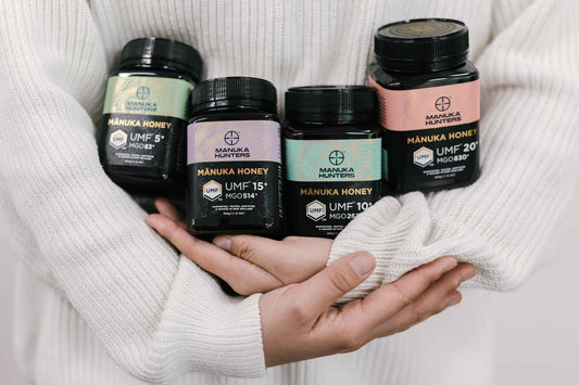 a woman craddling a range of manuka hunters honey jars in her arms