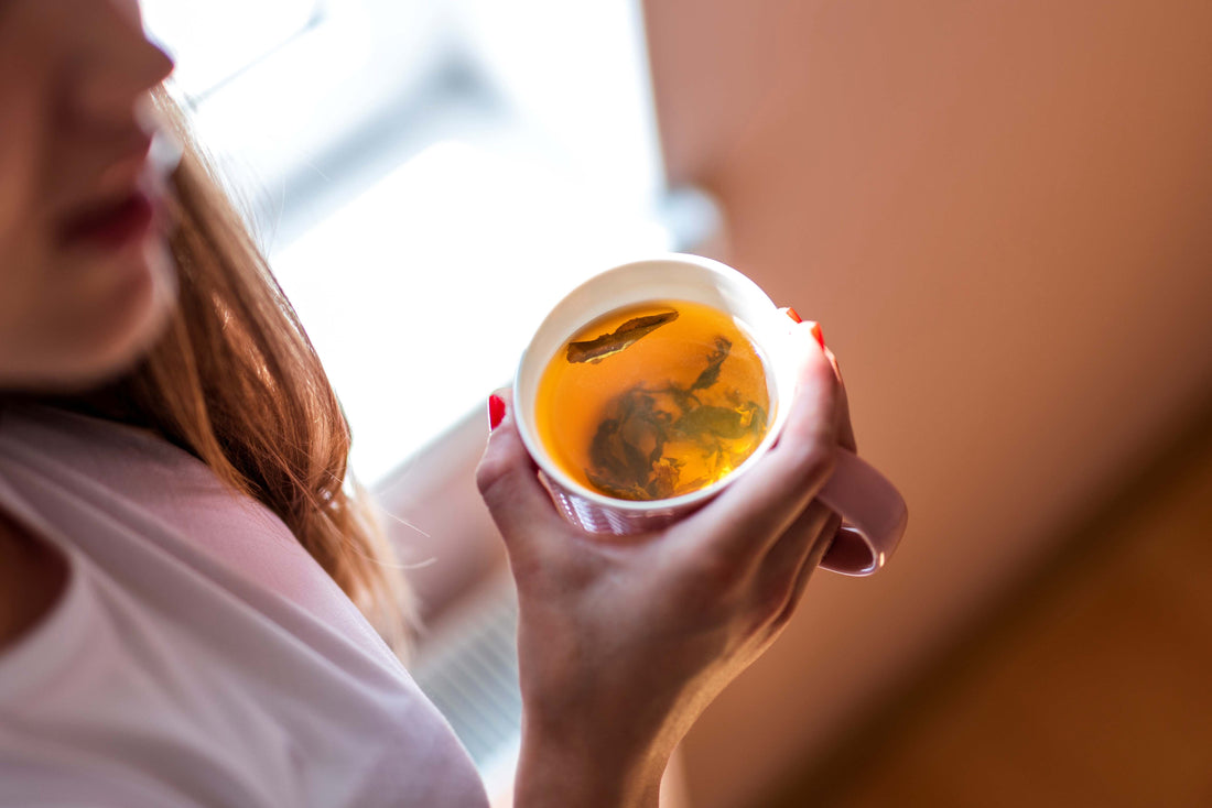 high-angle-shot-woman-holding-warm-drink-cup