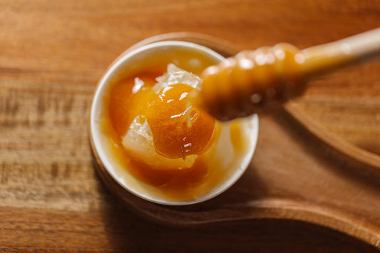 manuka honey stirred in a small bowl with a honey spoon