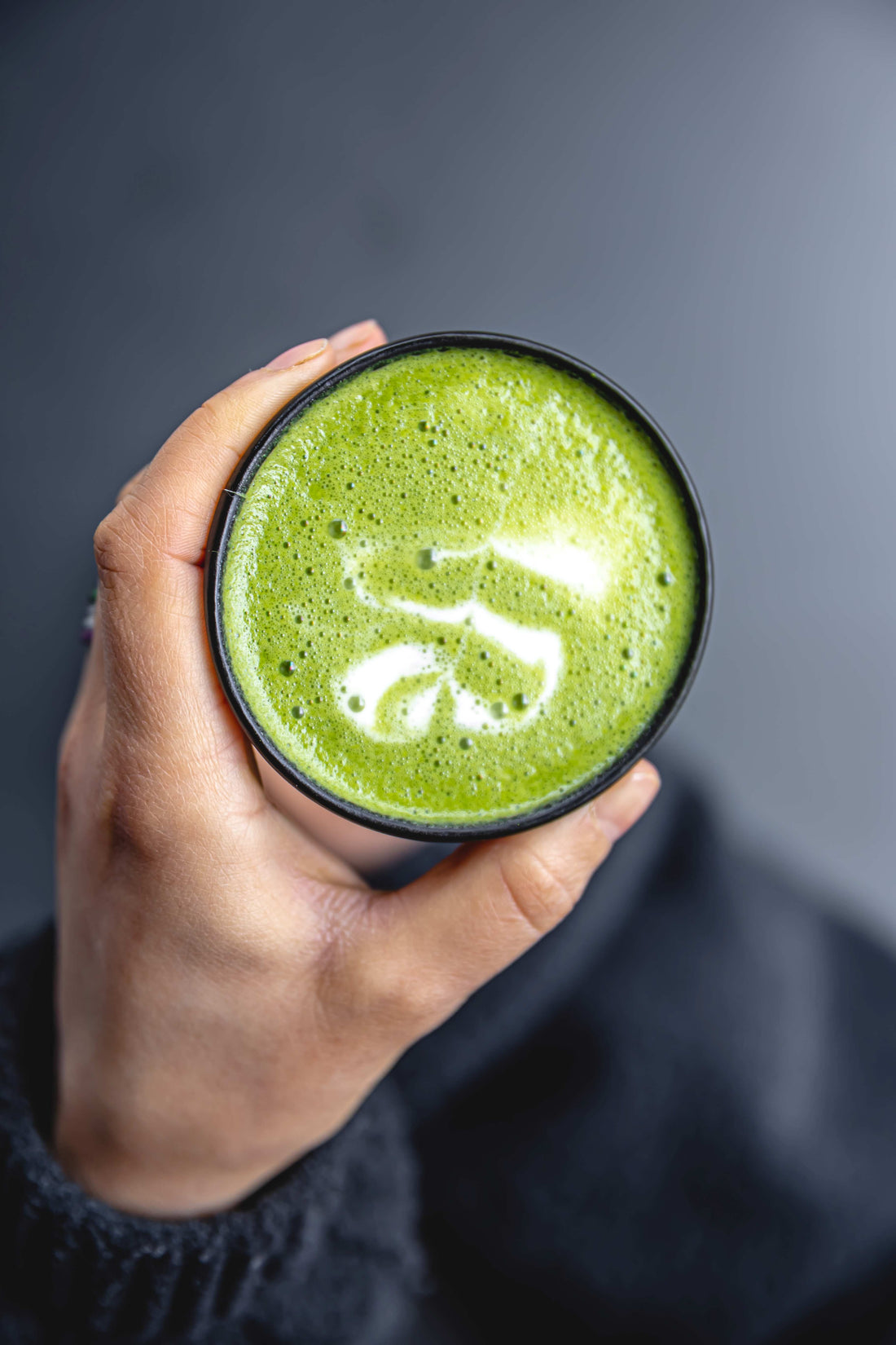 top-view-woman-holding-trendy-green-manuka-matcha-tea-drink-with-latte-art
